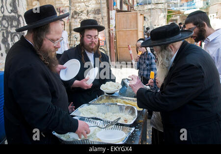 Ultra un ebreo ortodosso uomo distribuendo cibo ai bambini poveri di Gerusalemme in Israele Foto Stock