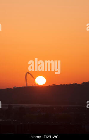 Londra, Regno Unito. Il 15 aprile 2015. Il sole sorge lungo l'arco a Wembley Stadium questa mattina, come si vede da una delle man-made tumuli al Northala campi, Northolt, in un giorno quando le temperature sono previsti in aumento di 25C. Credito: Stephen Chung / Alamy Live News Foto Stock