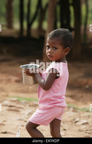 Una giovane ragazza porta una pentola di acqua a casa dal pozzo del villaggio; Kharigoda Village, Giajapati District, Orissa, India Foto Stock