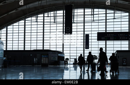 Shanghai, Cina - 6 Dicembre 2014: i passeggeri a piedi nella sala di attesa dell'Aeroporto Internazionale di Shanghai Pudong. Retro illuminato Foto Stock