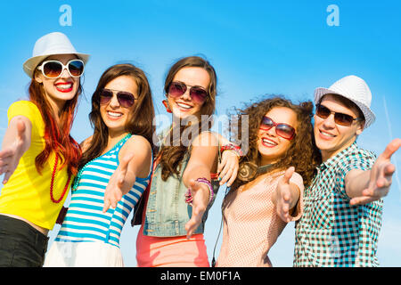 Un gruppo di giovani che indossa gli occhiali da sole e cappello Foto Stock