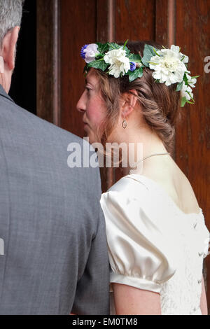 Sposa entrando porta della chiesa sul braccio di suo padre Foto Stock