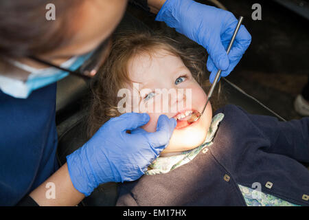 Il Toddler girl / 2 o 3 anni / due o tre anni di bambino durante il check up con il dentista per bambini / bambini pratica dentale. Regno Unito Foto Stock