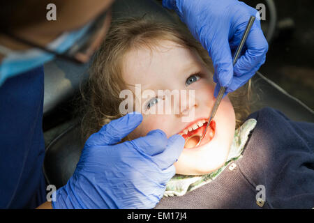 Il Toddler girl / 2 o 3 anni / due o tre anni di bambino durante il check up con il dentista per bambini / bambini pratica dentale. Regno Unito Foto Stock