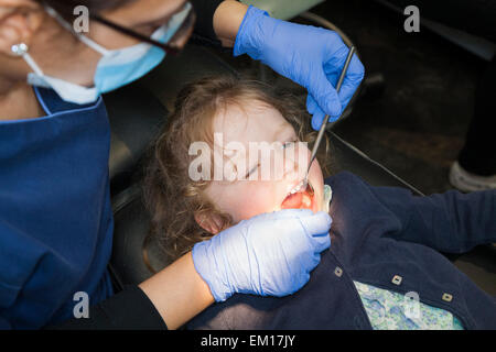 Il Toddler girl / 2 o 3 anni / due o tre anni di bambino durante il check up con il dentista per bambini / bambini pratica dentale. Regno Unito Foto Stock
