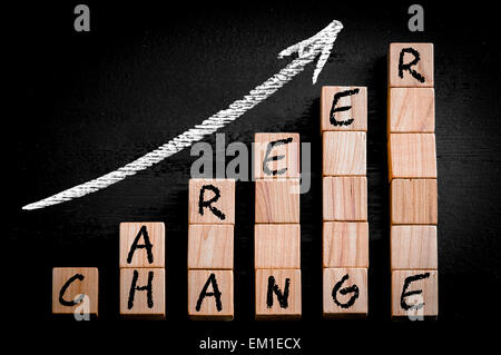 Messaggio di cambiamento di carriera sulla freccia ascendente al di sopra del grafico a barre di legno di cubetti isolati su sfondo nero. Foto Stock
