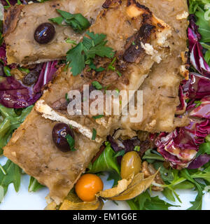 Classica francese pissaladière, una torta di cipolle, con una fresca insalata locale Foto Stock