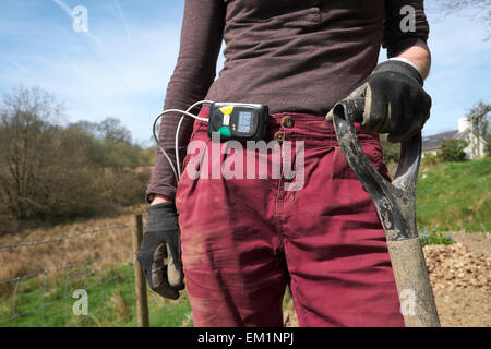 Lifecard CF cuore monitor usurato su un senior donna workng nel giardino Carmarthenshire in zone rurali del Galles UK KATHY DEWITT Foto Stock