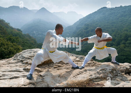 I monaci di Shaolin Songshan Tempio eseguire nei pressi di montagna Shaoshi, Zhengzhou, Dengeng County, nella provincia di Henan, Cina Foto Stock