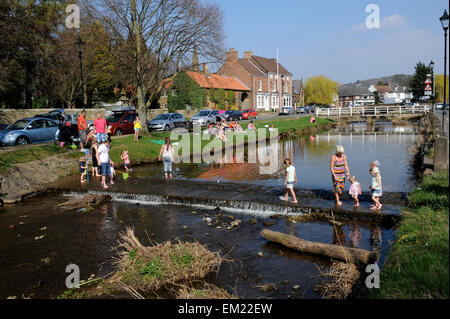 Famiglie paddling e la pesca nel fiume Leven in grande Ayton, North Yorkshire UK Gran Bretagna. Foto Stock