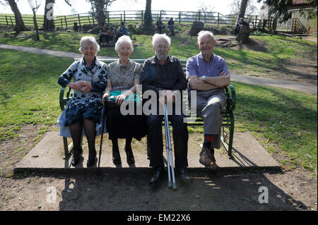 Quattro amici anziani ridere su un banco di lavoro in grande Ayton, North Yorkshire, Inghilterra, Gran Bretagna, North Yorkshire, Regno Unito. Foto Stock