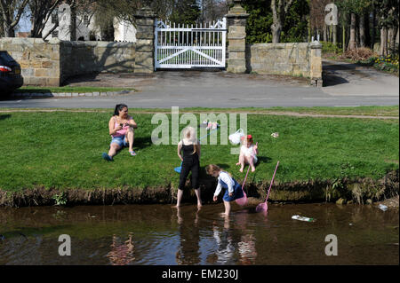 Famiglie paddling e la pesca nel fiume Leven in grande Ayton, North Yorkshire UK Gran Bretagna. Foto Stock