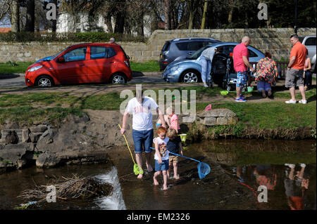 Famiglie paddling e la pesca nel fiume Leven in grande Ayton, North Yorkshire UK Gran Bretagna. Foto Stock