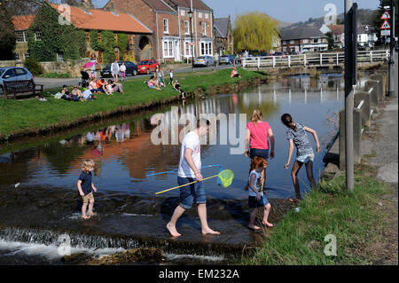 Famiglie paddling e la pesca nel fiume Leven in grande Ayton, North Yorkshire UK Gran Bretagna. Foto Stock