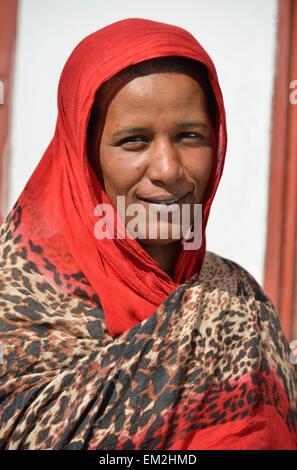 Ritratto di una donna Nubiano in tipico abito luminoso, davanti a casa sua, nel villaggio di Umogaal in Dongola, Valle del Nilo Foto Stock