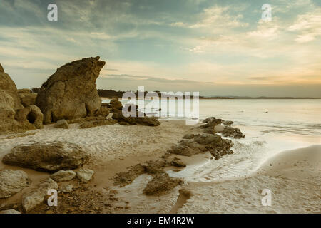 Tramonto su una spiaggia deserta con rocce in Loredo Cantabria, SPAGNA Foto Stock