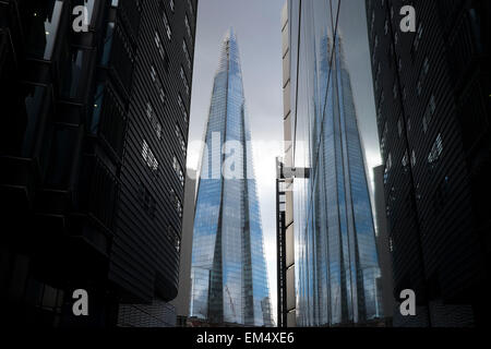 La Shard riflessa in doppio contro edifici alti in corrispondenza di più di Londra, Regno Unito. La Shard, indicato anche come il frammento di vetro, Shard London Bridge e formerly London Bridge Tower, è un 87-storey grattacielo a Londra che fa parte del London Bridge trimestre lo sviluppo. Foto Stock