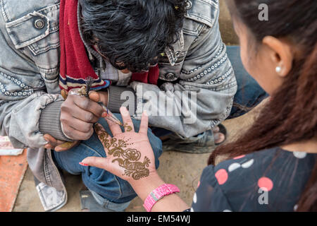 Tattoo Artist applicando hene tatuaggio su una donna in Kathmandu Foto Stock