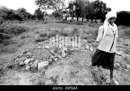 AIDS, la povertà e la siccità nelle zone rurali del kenia. Donna keniota. Suo marito è sepolto nel giardino. In Kitui famiglie seppellire i loro morti entro i limiti delle loro case. Lydia ha difficoltà a tirare avanti tutta la famiglia. Il sacerdote della chiesa cattolica Ikutha ha avuto pietà di lei e ha assunto il suo come un operatore sanitario le ragazze della scuola della parrocchia. Foto Stock