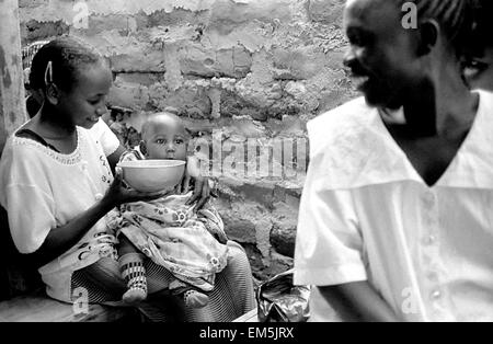 Una donna che nutre il suo bambino in un Harambee. Harambee è Swahili per "tirare tutti insieme". Vi invitiamo a unirvi a noi, tirando togeth Foto Stock