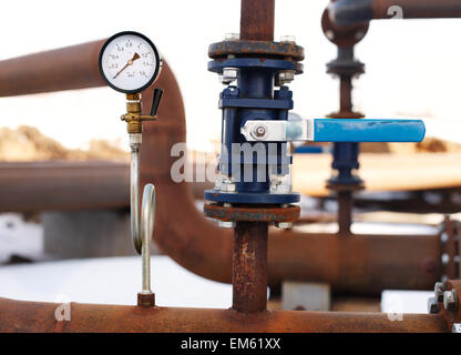 Valvola blu e il manometro sul tubo arrugginito Foto Stock