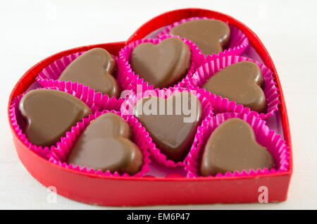 Deliziosamente guardando al cioccolato a forma di cuore in un cuore rosso scatola sagomata Foto Stock