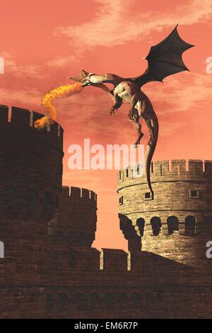 Incendio respirazione dragon in volo di attaccare il castello medievale sotto il cielo arancione Foto Stock