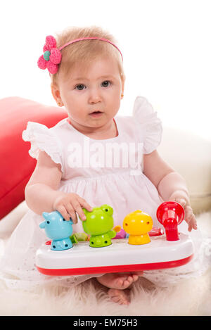 Bellezza bambina di otto mesi di età giocando con i giocattoli colorati con animali Foto Stock