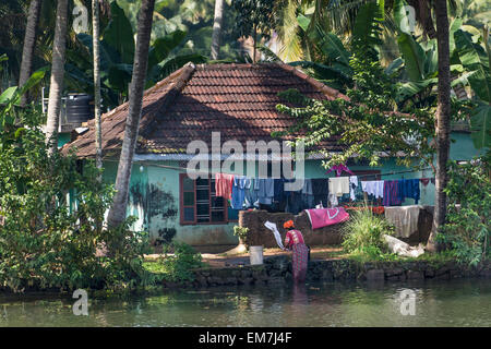 La donna il lavaggio della biancheria in un canale, il sistema di canale di lagune, Champakulam, Kerala, India Foto Stock