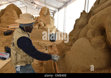 Elstal, Germania. Xvii Apr, 2015. Bob Attiso dal Togo opere sulla sua la scultura di sabbia in Elstal, Germania, 17 aprile 2015. Utilizzando 1.100 tonnellate di sabbia, 20 artisti internazionali di portare le loro nozioni del mondo africano per la vita al primo Sandworld Berlino. La mostra si apre il 01 maggio 2015 in Karls adventure village. Foto: BERND SETTNIK/ZB/dpa/Alamy Live News Foto Stock