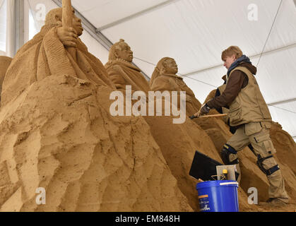 Elstal, Germania. Xvii Apr, 2015. Malja Puncule dalla Lettonia lavora su di lei la scultura di sabbia in Elstal, Germania, 17 aprile 2015. Utilizzando 1.100 tonnellate di sabbia, 20 artisti internazionali di portare le loro nozioni del mondo africano per la vita al primo Sandworld Berlino. La mostra si apre il 01 maggio 2015 in Karls adventure village. Foto: BERND SETTNIK/ZB/dpa/Alamy Live News Foto Stock