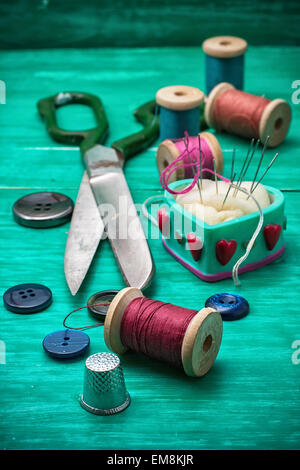 I pulsanti di filettatura per l'artigianato in legno color turchese sfondo.Il fuoco selettivo Foto Stock