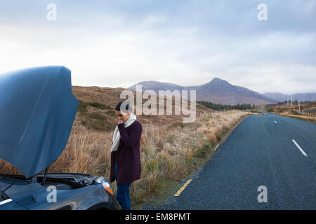 Donna dal veicolo bloccato in strada, Connemara, Irlanda Foto Stock