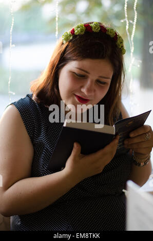 Ritratto di una adolescente libro di lettura con i suoi amici Foto Stock