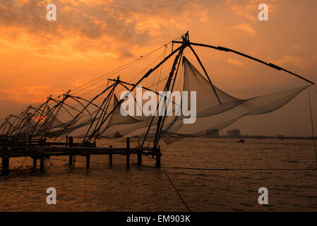 Tramonto dai cinesi le reti da pesca in Fort Kochi, Kerala India Foto Stock