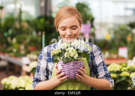 Donna felice profumati fiori in serra Foto Stock