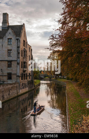 L'uomo punting sul fiume Cam in Cambridge in autunno con il ponte di matematica a distanza Foto Stock