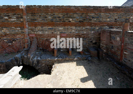 Vista di un pozzo e il negozio che rivestivano l'antico colonnato romano street presso la città antica sardi, giorno moderno Sart, Turchia. Foto Stock