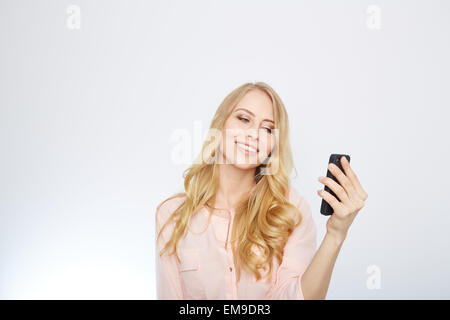 Ragazza con un telefono intelligente. isolato su bianco. Foto Stock