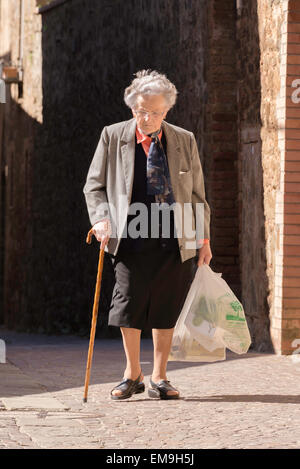 Old Lady andando a casa da shopping a Montalcino, Toscana, Italia Foto Stock