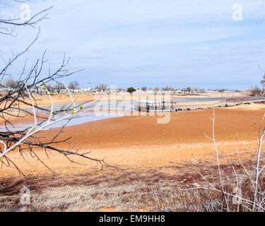 Una rampa di pesca è a filamento di sinistra nel fango e acqua bassa in colpite dalla siccità Lago Hefner, Oklahoma City, Oklahoma, Stati Uniti d'America Foto Stock