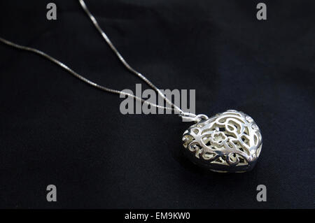 Intricato elegante cuore silver necklace su sfondo nero Foto Stock