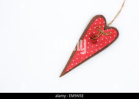 Un rosso di legno decorativo cuore su uno sfondo bianco. Foto Stock