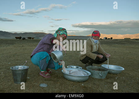 Il kazako donne preparano gli intestini di capra per preparare le salsicce al tramonto a ger camp, Mongolia occidentale Foto Stock
