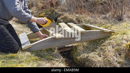 L'uomo costruire una piccola curva di legno di legno impregnato Foto Stock