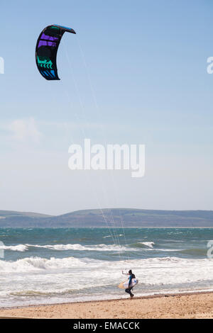 Bournemouth, Dorset, Regno Unito. 18 aprile 2015. UK Meteo: Condizioni meteo molto ventose a Bournemouth Beach - kitesurfer tenendo la tavola si dirige verso il mare. Kitesurfers kite surfer kitesboarders kite boarder kitesurf kite surf kitesboarder kite boarder credito: Carolyn Jenkins/Alamy Live News Foto Stock