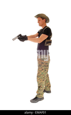 Un soldato nel Pantalone mimetico, cappello e black t-shirt puntando la sua pistola a mano isolati su sfondo bianco. Foto Stock