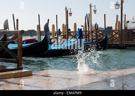 Le onde rompono oltre il bordo della Piazza San Marco durante la estrema alta marea, Venezia, Italia Foto Stock