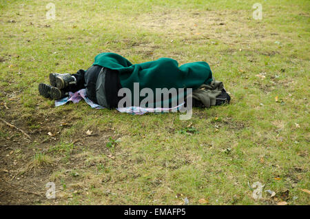 Un uomo senza tetto dorme in un parco di Montreal Foto Stock