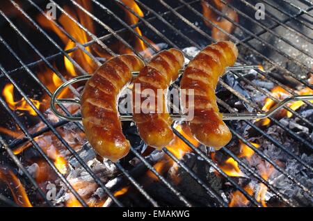 Salsicce sulla forcella sullo sfondo barbeque Foto Stock